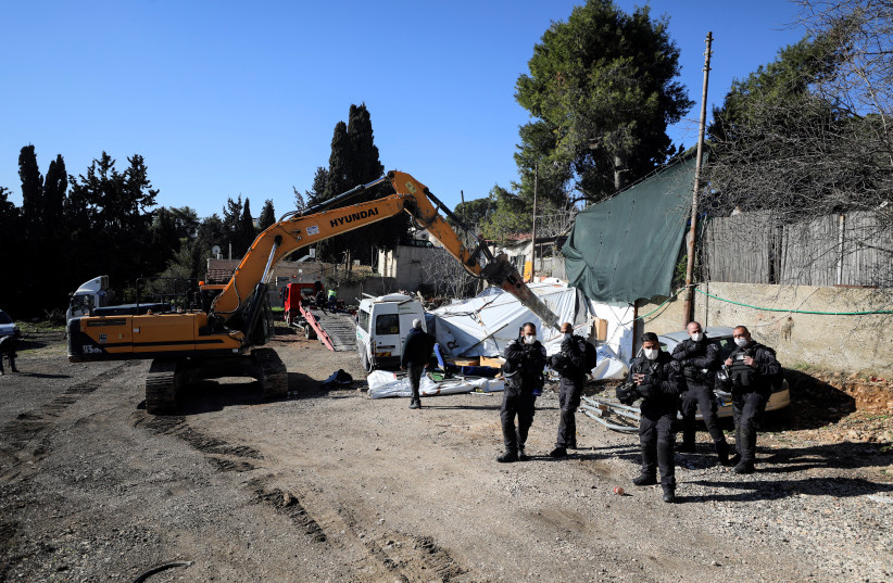  Israeli police stand guard during the demolition of structures outside the home of a Palestinian family facing eviction in East Jerusalem January 17, 2022. (photo credit: REUTERS/AMMAR AWAD)