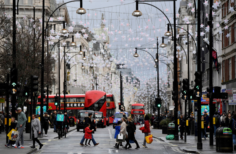 Shoppers cross Oxford Street, London, Britain, December 28, 2021. (photo credit: REUTERS/TOBY MELVILLE/FILE PHOTO)
