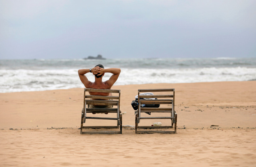  A tourist rests on a beach near hotels in a tourist area in Bentota, Sri Lanka May 2, 2019. Picture take May 2, 2019.  (credit: REUTERS/DINUKA LIYANAWATTE)