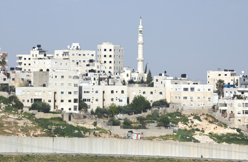  PALESTINIAN RESIDENTIAL buildings and a mosque are seen past Israel’s separation wall, which surrounds the Shuafat refugee camp in east Jerusalem.  (credit: GILI YAARI/FLASH90)