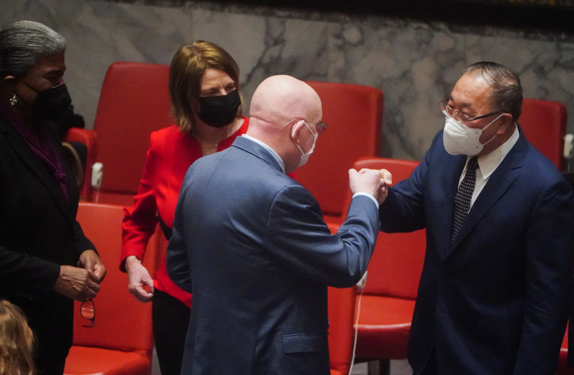  Russian Ambassador to the UN Vasily Nebenzya bumps fists with Permanent Representative of China to the UN Zhang Jun as the United Nations Security Council meets after Russia recognized two breakaway regions in eastern Ukraine as independent entities, in New York City, US. February 21, 2022.  (photo credit: CARLO ALLEGRI/REUTERS)