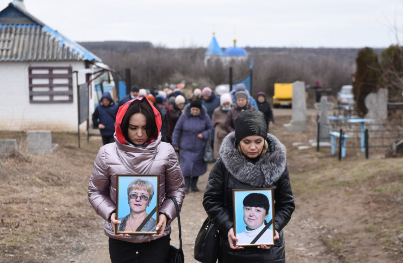  Women carry portraits of school teachers Yelena Ivanova and Yelena Kudrik, who were killed by shelling, during a funeral at a cemetery in the separatist-controlled town of Horlivka (Gorlovka) in the Donetsk region, Ukraine, February 28, 2022. (credit: REUTERS/STRINGER)