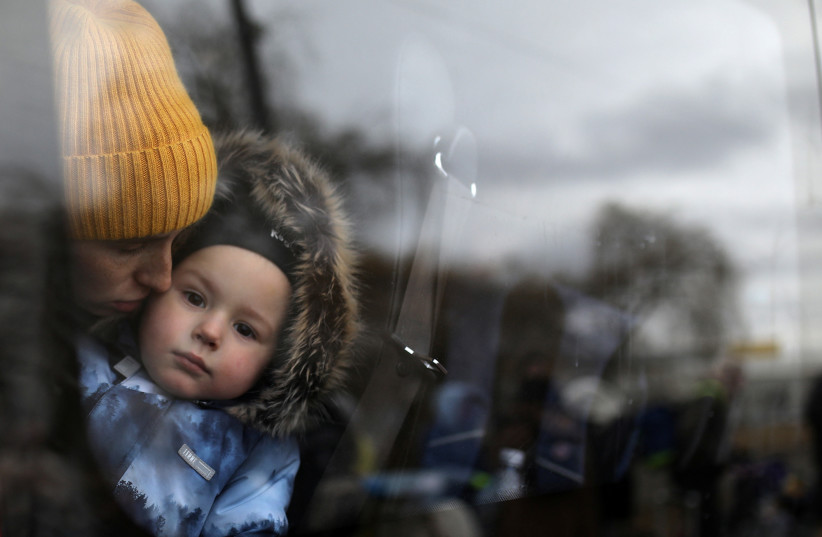  A woman and a child wait in a bus after fleeing from Russia's invasion of Ukraine, at the border crossing in Siret, Romania, March 1, 2022. (photo credit: REUTERS/STOYAN NENOV)