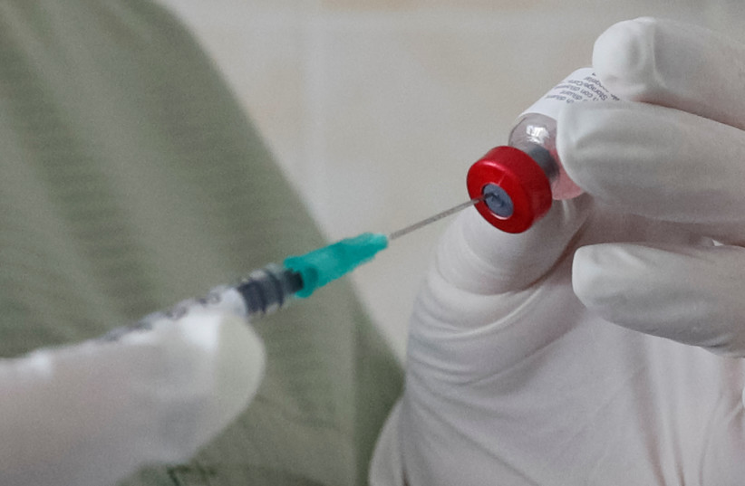 A nurse fills a syringe with a vaccine before administering an injection at a kids clinic in Kiev, Ukraine August 14, 2019 (photo credit: REUTERS/VALENTYN OGIRENKO)