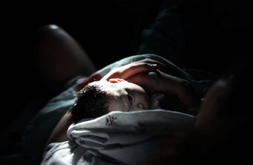  A newborn baby lying on her mother moments after birth in a delivery room at the Hadassah Ein Kerem hospital in Jerusalem on June 18, 2011.   (credit: KOBI GIDEON/FLASH90)