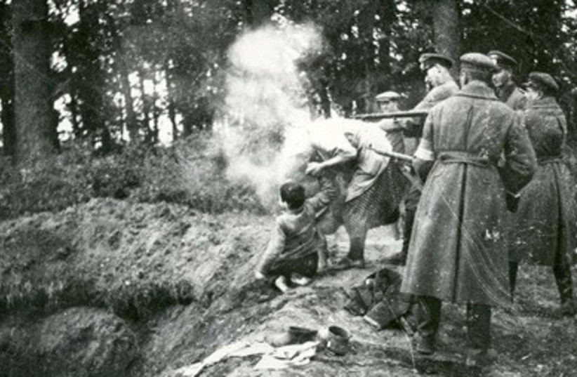  A mother holds her son's hand in front of a mass grave as Nazis stand behind her (photo credit: Security Services Archive, Historical Collection of the State Security Service Prague)