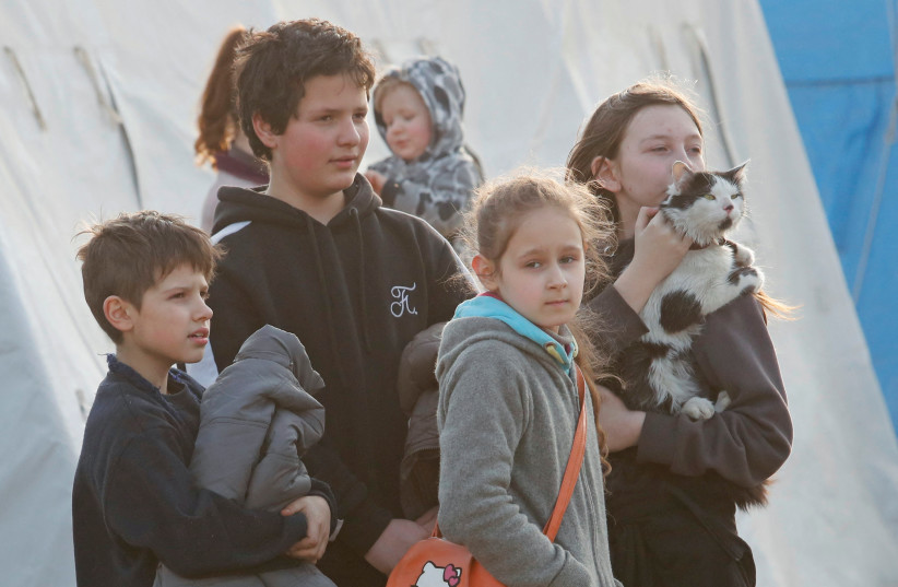  Children are seen with a cat at a temporary accommodation centre for evacuees during Ukraine-Russia conflict in the village of Bezimenne in the Donetsk Region, Ukraine May 1, 2022. (credit: REUTERS/ALEXANDER ERMOCHENKO)