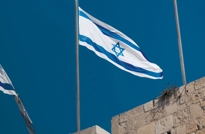  The Israeli flag flying above Jerusalem's Old City. (credit: Levi Meir Clancy/Unsplash)