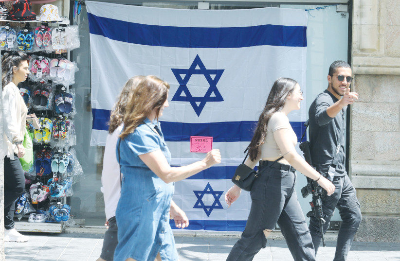  PEOPLE IN downtown Jerusalem walk past flags on sale for Independence Day this week. (credit: MARC ISRAEL SELLEM/THE JERUSALEM POST)