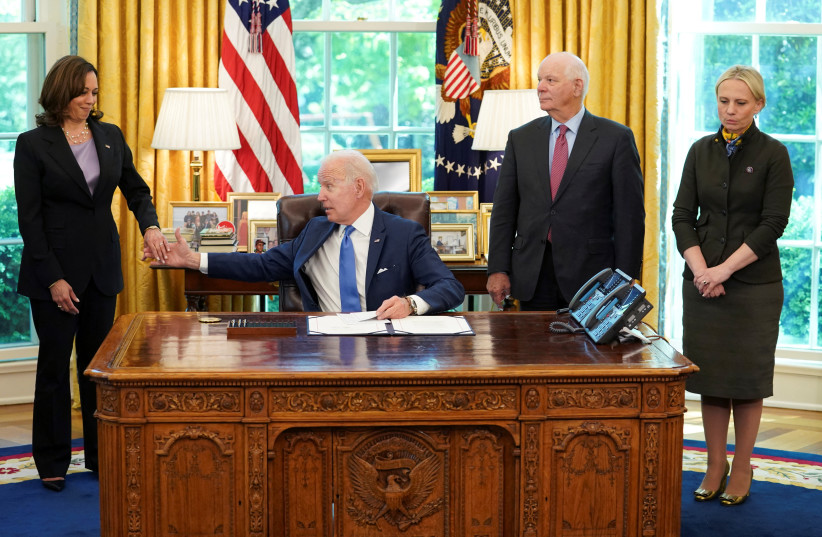  US President Joe Biden clasps hands with Vice President Kamala Harris as Sen. Ben Cardin (D-MD) and Representative Victoria Spartz (R-IN) wait for Biden to into law S. 3522, the ''Ukraine Democracy Defense Lend-Lease Act of 2022'' at the White House in Washington, US, May 9, 2022.  (credit: KEVIN LAMARQUE/REUTERS)