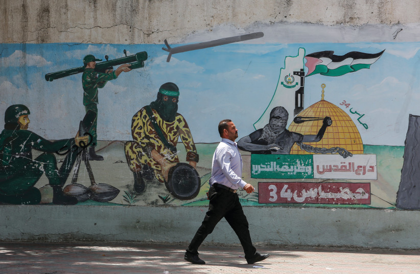  HAMAS ABIDES by its charter: Graffiti depicts Hamas fighters firing rockets, in Khan Younis, May 30. (credit: ABED RAHIM KHATIB/FLASH90)