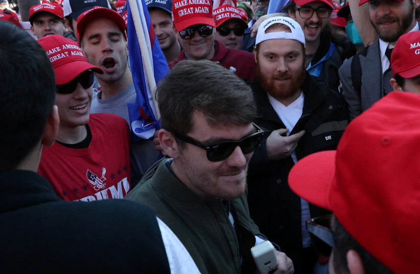 Supporters of the America First ideology and US President Donald Trump cheer on Nick Fuentes, a leader of the America First movement and a white nationalist, as he makes his way through the crowd for a speech during the "Stop the Steal" and "Million MAGA March" protests, November 14, 2020. (photo credit: REUTERS/LEAH MILLIS)