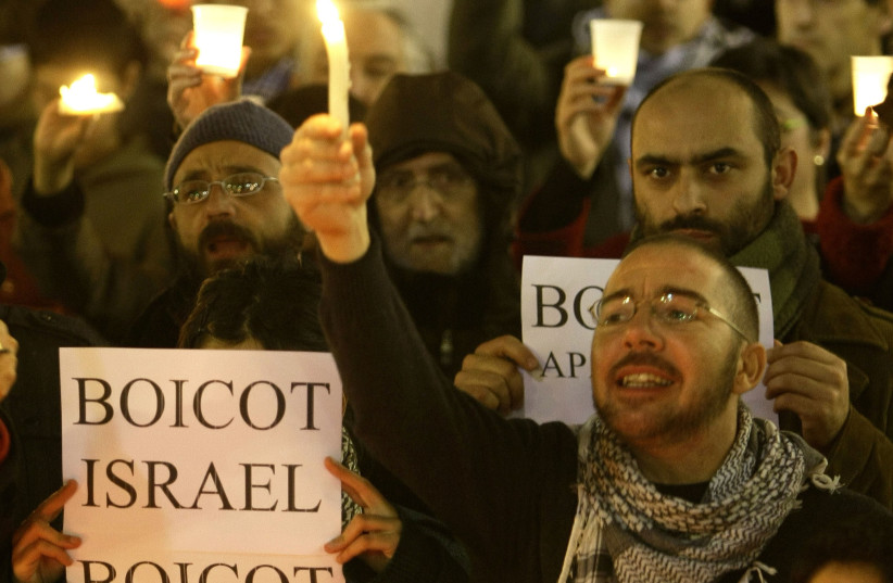  Pro-Palestinian demonstrators hold candles during a protest in front of Catalan Government in Sant Jaume quarter in central Barcelona January 16, 2009 against Israel's attacks on Gaza. The sign reads: ''Boycott Israel, boycott apartheid''. (credit: REUTERS/GUSTAU NACARINO)