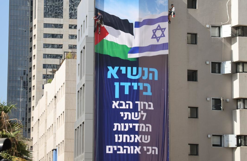  Peace Now hangs a welcome Biden sign featuring Palestinian and Israeli flags in 2022. (credit: PEACE NOW)