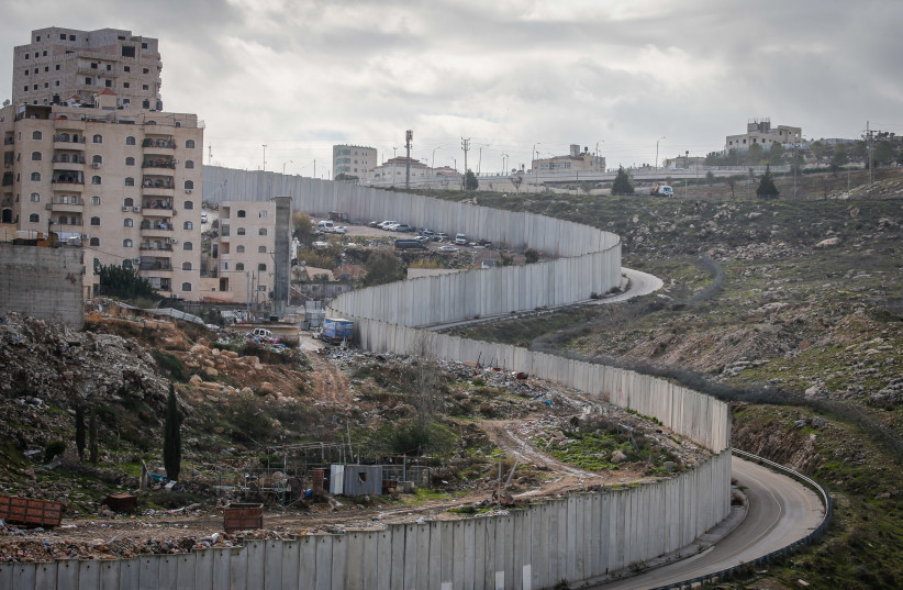  View of a section of Israel's separation barrier dividing the Palestinian Shuafat refugee camp from the Jewish neighborhood of Pisgat Zeev, on January 23, 2022. (credit: JAMAL AWAD/FLASH90)