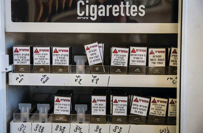  CIGARETTES ON display at a convenience store in Safed carry warnings that smoking causes cancer, heart disease, stroke and other harm to smokers and their children.  (credit: David Cohen/Flash90)