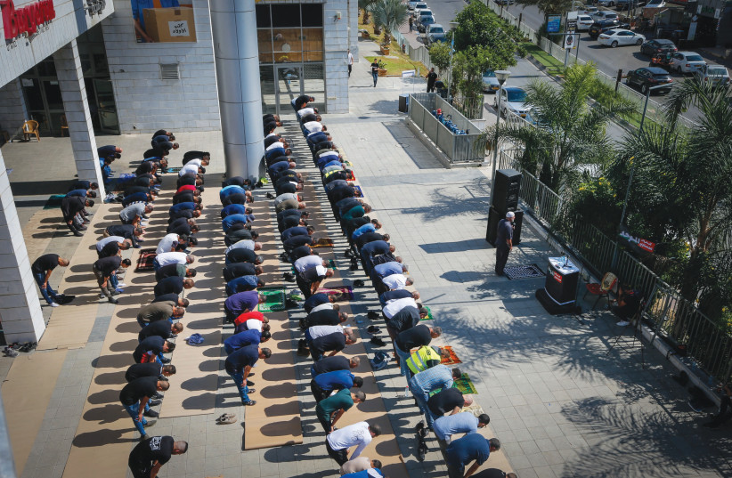 ISRAELI ARABS pray during a protest again violence, organized crime and recent killings among their communities, in Umm el-Fahm.