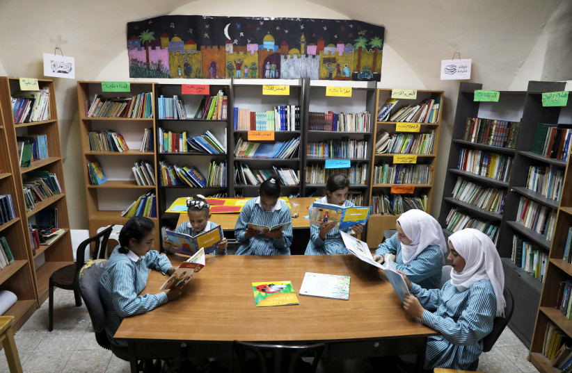  Palestinian schoolgirls read books in a library at school run by UNRWA (United Nations Relief and Works Agency) in Silwan in East Jerusalem October 10, 2018 (credit: AMMAR AWAD/REUTERS)
