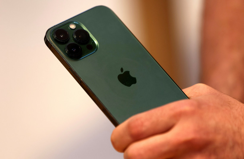  A customers holds the new green colour Apple iPhone 13 pro shortly after it went on sale inside the Apple Store on 5th Avenue in Manhattan in New York City, New York, US, March 18, 2022. (photo credit: REUTERS/MIKE SEGAR)