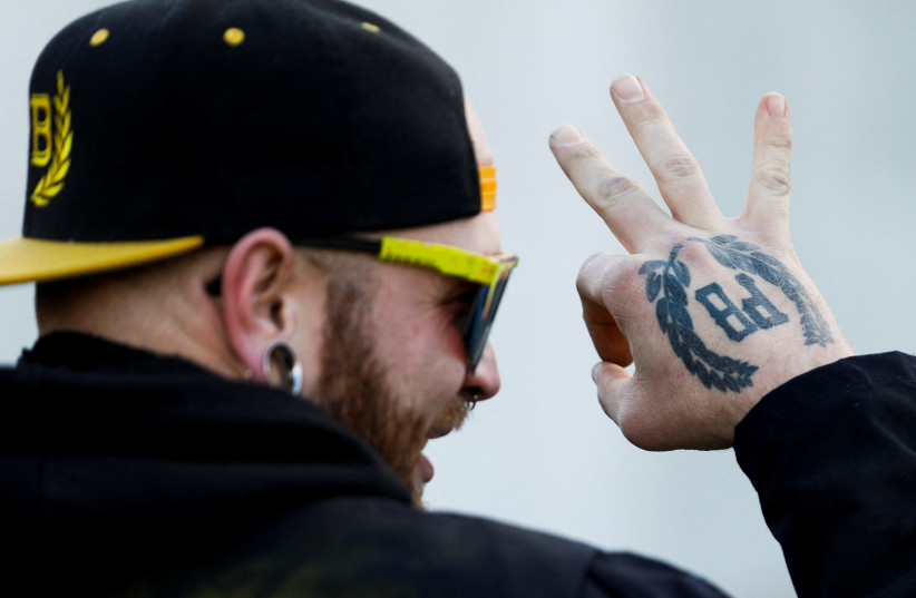  A member of the Proud Boys gestures in front of the Oregon State Capitol during a protest in support of the January 6th attack on the US Capitol in Washington, in Salem, Oregon, US, January 8, 2022.  (photo credit: REUTERS/JOHN RUDOFF)