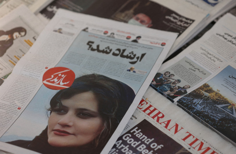 A newspaper with a cover picture of Mahsa Amini, a woman who died after being arrested by Iranian morality police is seen in Tehran, Iran, September 18, 2022. (credit: MAJID ASGARIPOUR/WANA/REUTERS)