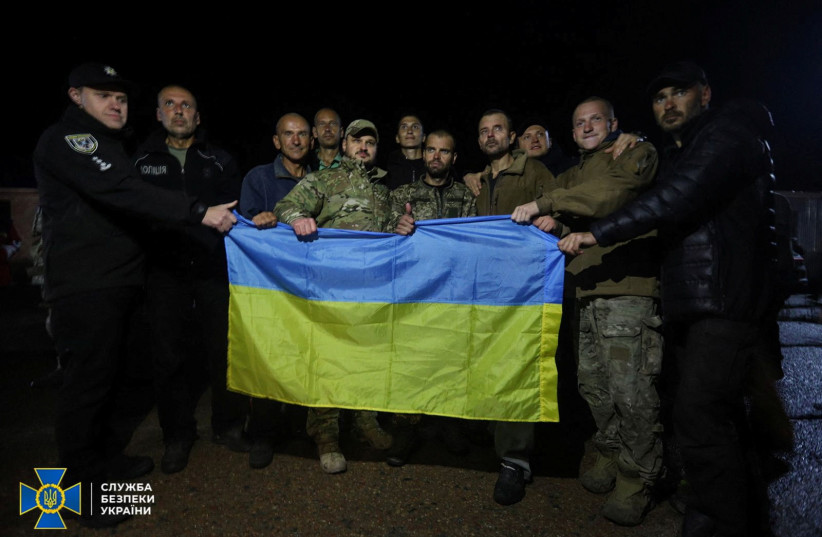  Ukrainian prisoners of war (POWs) pose for a picture with a national flag after a swapping, amid Russia's attack on Ukraine, in Chernihiv region, Ukraine, in this handout picture released September 22, 2022 (credit: Press Service of the State Security Service of Ukraine/Handout via REUTERS)