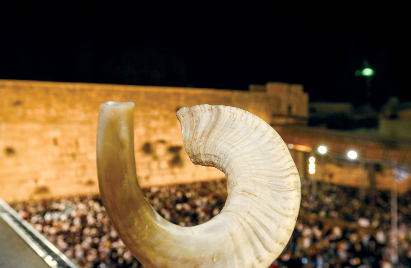  A shofar is held up at the Western Wall. (credit: MARC ISRAEL SELLEM)