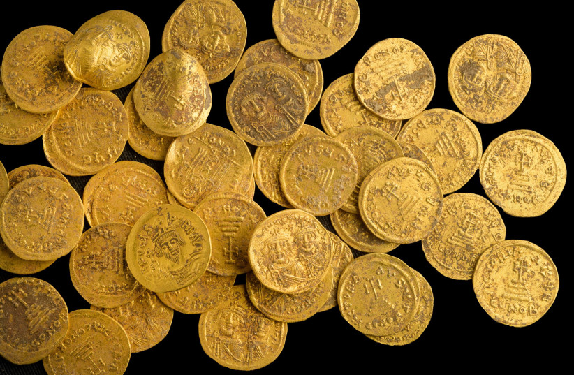 A cache of 44 solid gold coins from the Byzantine-era was discovered in Banias Nature Reserve, October 3, 2022 (credit: DAFNA GAZIT/ISRAEL ANTIQUITIES AUTHORITY)