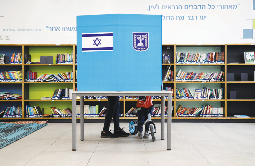  A VOTER selects a ballot during the country’s general election, at a Tel Aviv polling station. (credit: CORINNA KERN/REUTERS)