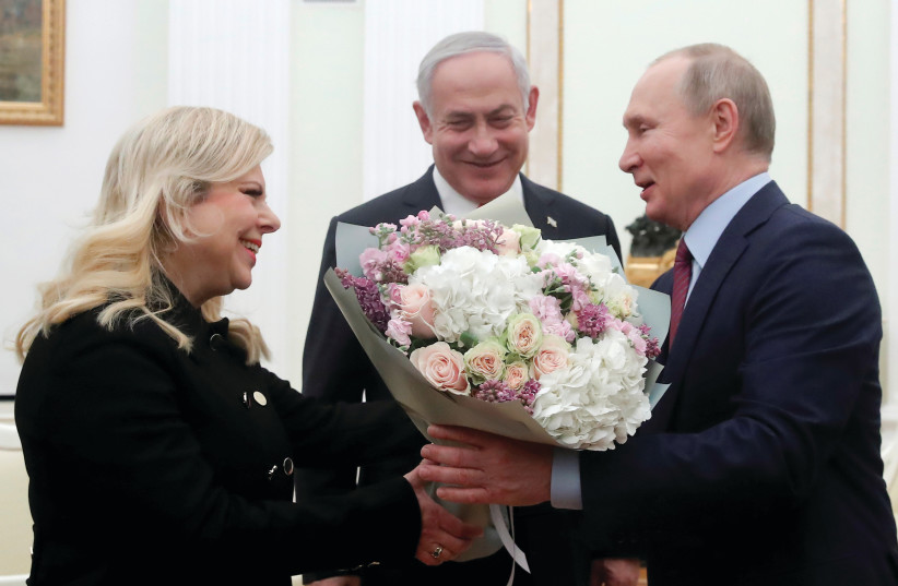  THEN-PRIME minister Benjamin Netanyahu looks as his wife Sara receives flowers from Russian President Vladimir Putin as they meet in Moscow, in 2020. (credit: MAXIM SHEMETOV/REUTERS)