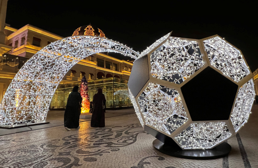 People walk past an illuminated soccer ball ahead of the FIFA 2022 World cup soccer tournament at Katara Cultural Village in Doha, Qatar November 15, 2022.