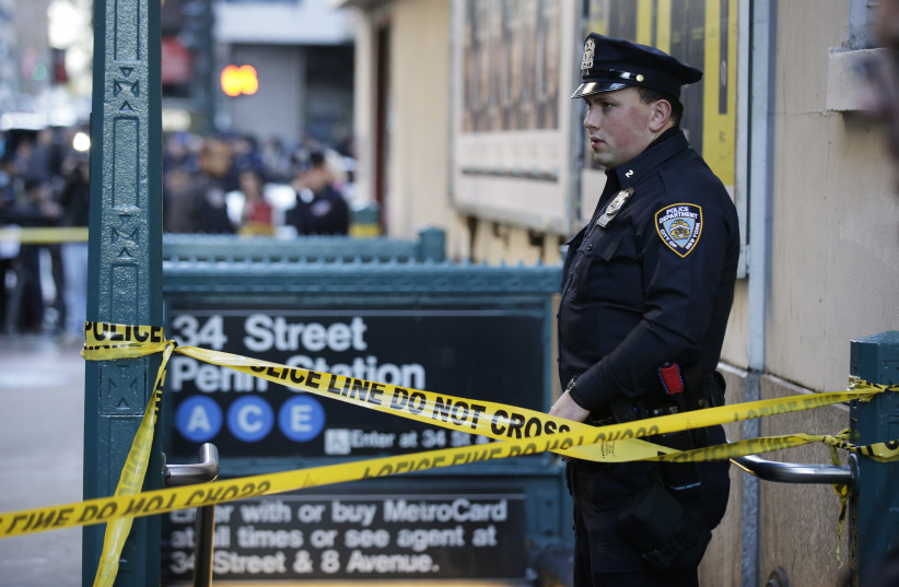  A NYPD officer stands guard near the Penn Station where streets have been closed following an early morning shooting in Manhattan New York, November 9, 2015.  (credit: BRENDAN MCDERMID/REUTERS)