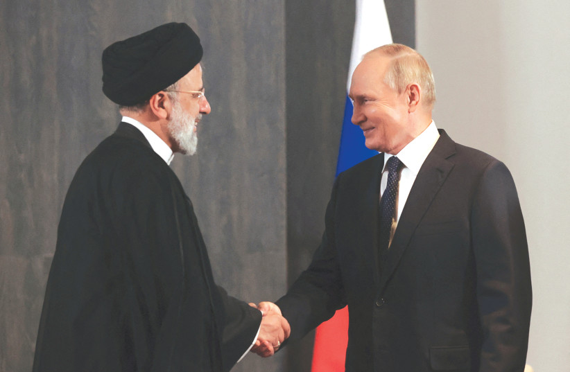 RUSSIAN PRESIDENT Vladimir Putin shakes hands with Iranian President Ebrahim Raisi during a meeting in September (credit: SPUTNIK/REUTERS)