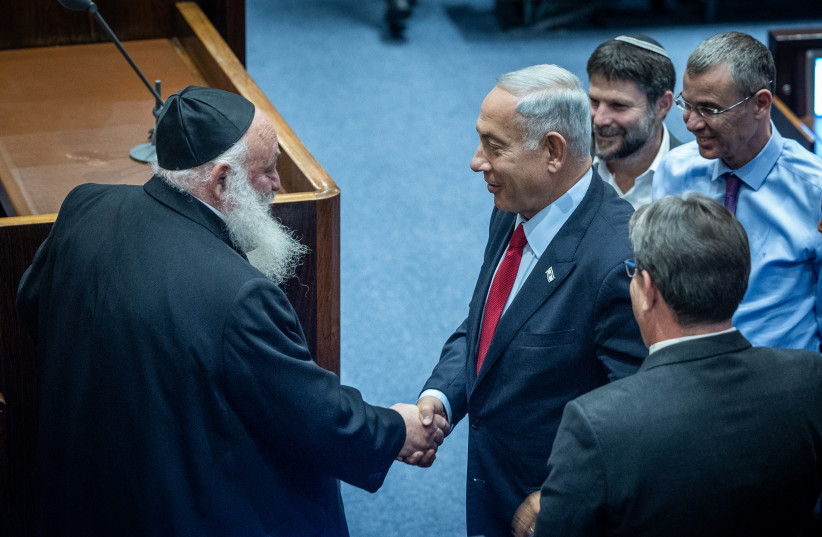  Likud party chairman MK Benjamin Netanyahu shake hands with United Torah Judaism MK Yitzchak Goldknopf a plenum session in the assembly hall of the parliament (Knesset) on November 21, 2022.  (credit: YONATAN SINDEL/FLASH90)