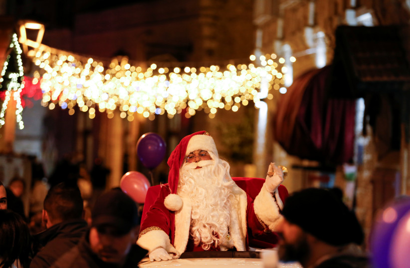  A Palestinian dressed as Santa gestures during a celebration in Bethlehem, in the West Bank, December 2, 2021. Picture taken December 2, 2021.  (credit: REUTERS/MUSSA QAWASMA)