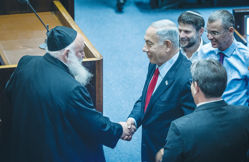  LIKUD LEADER BENJAMIN Netanyahu shakes hands with United Torah Judaism MK Yitzhak Goldknopf in the Knesset last week. If Netanyahu’s promise of a full budget for all haredi educational institutions is realized, the already-low incentive to provide core studies will disappear entirely. (credit: YONATAN SINDEL/FLASH90)