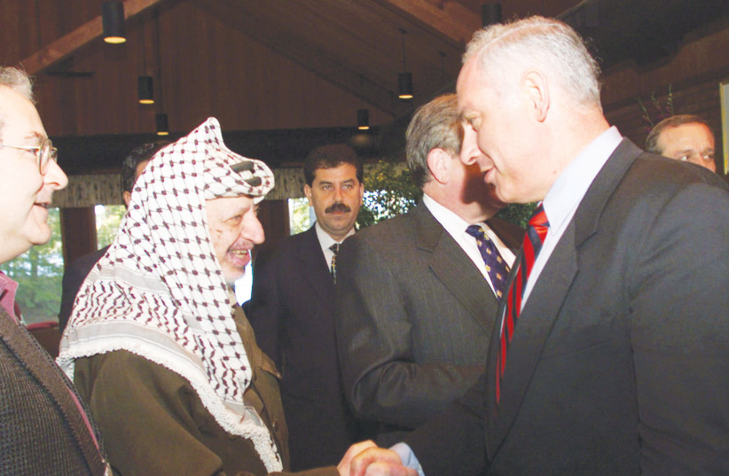  BENJAMIN NETANYAHU, in his first term as prime minister, shakes hands with then-PA head Yasser Arafat at the Middle East peace summit at Wye River, Maryland, 1998. Netanyahu, with the aid of Palestinian terrorists, helped scuttle the Oslo Accords, says the writer. (credit: REUTERS)