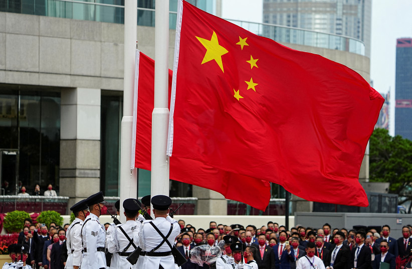  Police officers raise Chinese and Hong Kong flags during a ceremony to mark the Chinese National Day in Hong Kong, China October 1, 2022. (photo credit: REUTERS/LAM YIK)