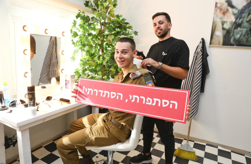  Lone soldier getting a haircut from volunteer barber during the FIDF- Nefesh B’Nefesh Lone Soldiers Errands Day (credit: YONIT SHILLER)