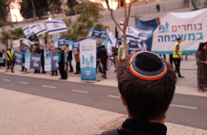  LGBT Rights activists wave flags and protest as religious Jewish activitsts protest against same-sex parenting and LGBT families, in Tel Aviv, on December 16, 2018.  (credit: TOMER NEUBERG/FLASH90)