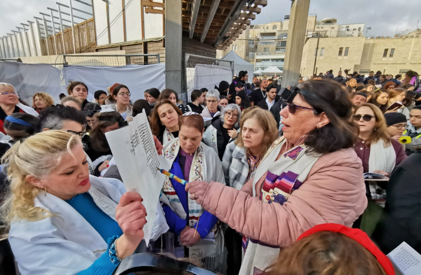  Women of the Wall read from a Torah scroll at the Western Wall on the seventh day of Hanukkah, December 25, 2022. (photo credit: WOMEN OF THE WALL)