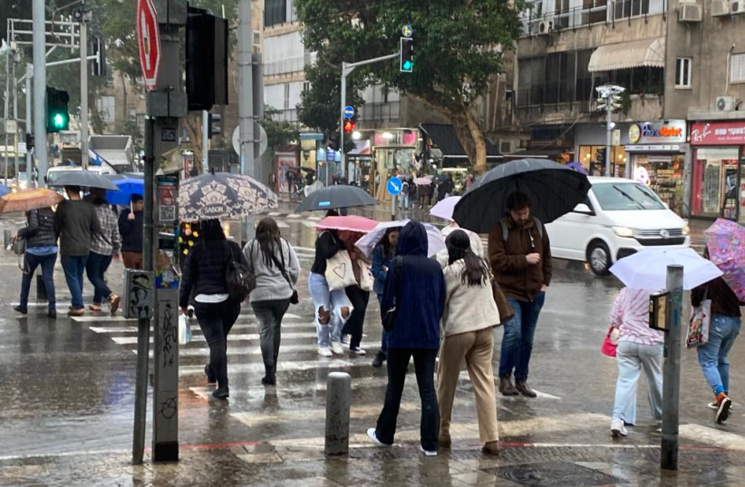  Israelis in the rain, December 25, 2022. (photo credit: AVSHALOM SASSONI/MAARIV)