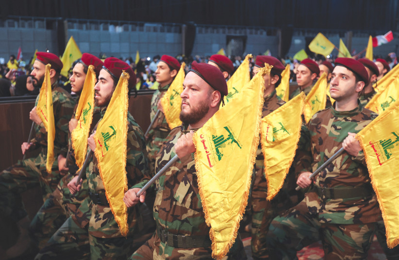  HEZBOLLAH MEMBERS hold flags during a rally marking the annual Hezbollah Martyrs’ Day, in Beirut’s southern suburbs, last month (photo credit: AZIZ TAHER/REUTERS)