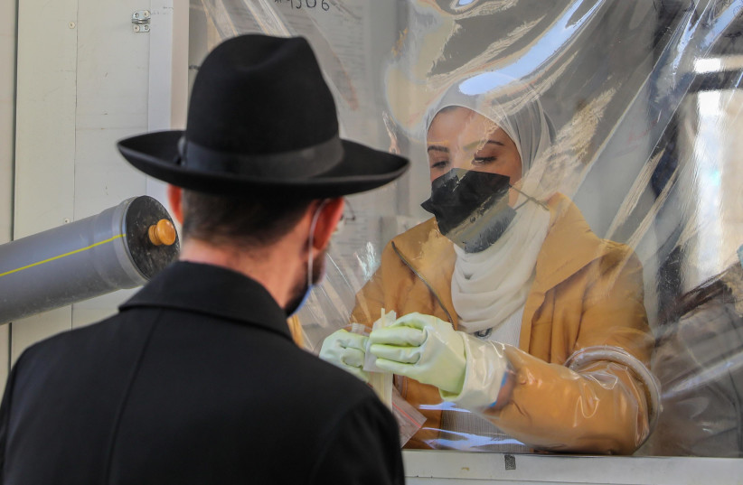  A coronavirus test in Jerusalem. COVID goes beyond conflict and affects everyone. January 2022. (photo credit: MARC ISRAEL SELLEM/THE JERUSALEM POST)