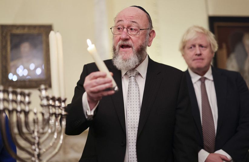  UK Chief Rabbi Ephraim Mirvis lights Hanukkah candles with then-UK prime minister Boris Johnson (Illustrative). (credit: Number 10/Flickr)