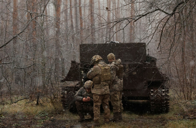 Soldiers with the 80th Separate Air Assault Brigade use their phones next to an APC at the front line on Orthodox Christmas, during a ceasefire announced by Russia over the Orthodox Christmas period, from the frontline region of Kreminna, Ukraine, January 6, 2023. (photo credit: CLODAGH KILCOYNE/REUTERS)