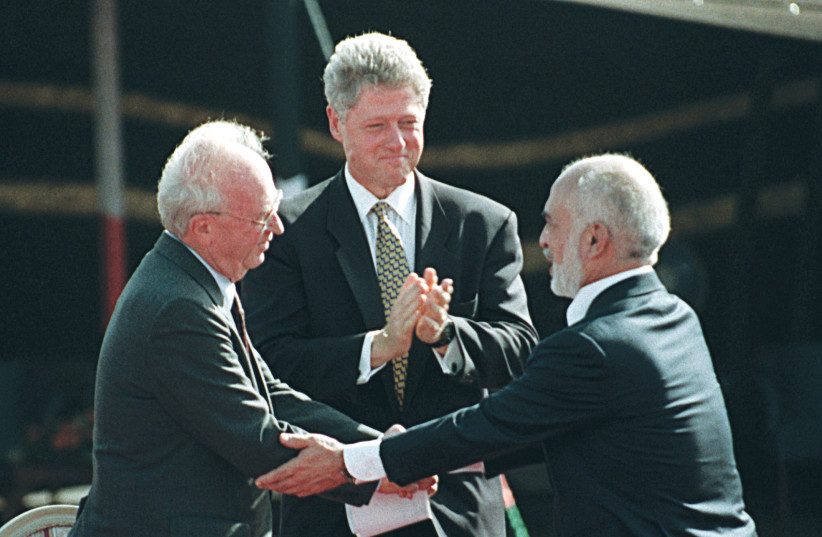  THEN-PRIME MINISTER Yitzhak Rabin and Jordan’s King Hussein shake hands, as then-US president Bill Clinton applauds, at the peace treaty signing ceremony at the border between the two countries, in 1994. (credit: REUTERS)