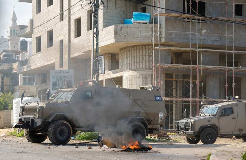 Israeli military vehicles are seen during clashes with Palestinians during a raid in Jenin in the West Bank January 26, 2023 (credit: REUTERS/RANEEN SAWAFTA)