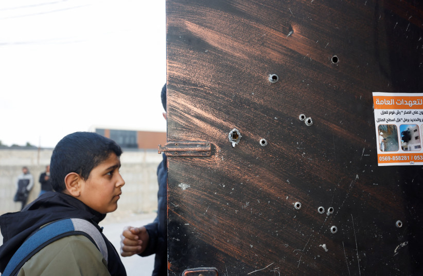 Bullet holes are pictured on a door at the scene where Israeli forces clashed with Palestinian gunmen during a raid near the city of Jericho on February 6, 2023.  (credit: REUTERS/MOHAMAD TOROKMAN)