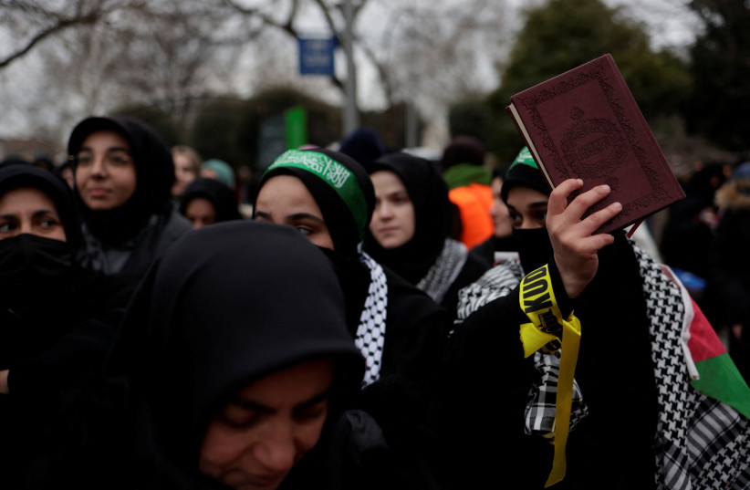  A woman holds a copy of the Koran during a protest following the burning of the Koran in Stockholm, in Istanbul, Turkey January 29, 2023. (credit: MURAD SEZER/REUTERS)